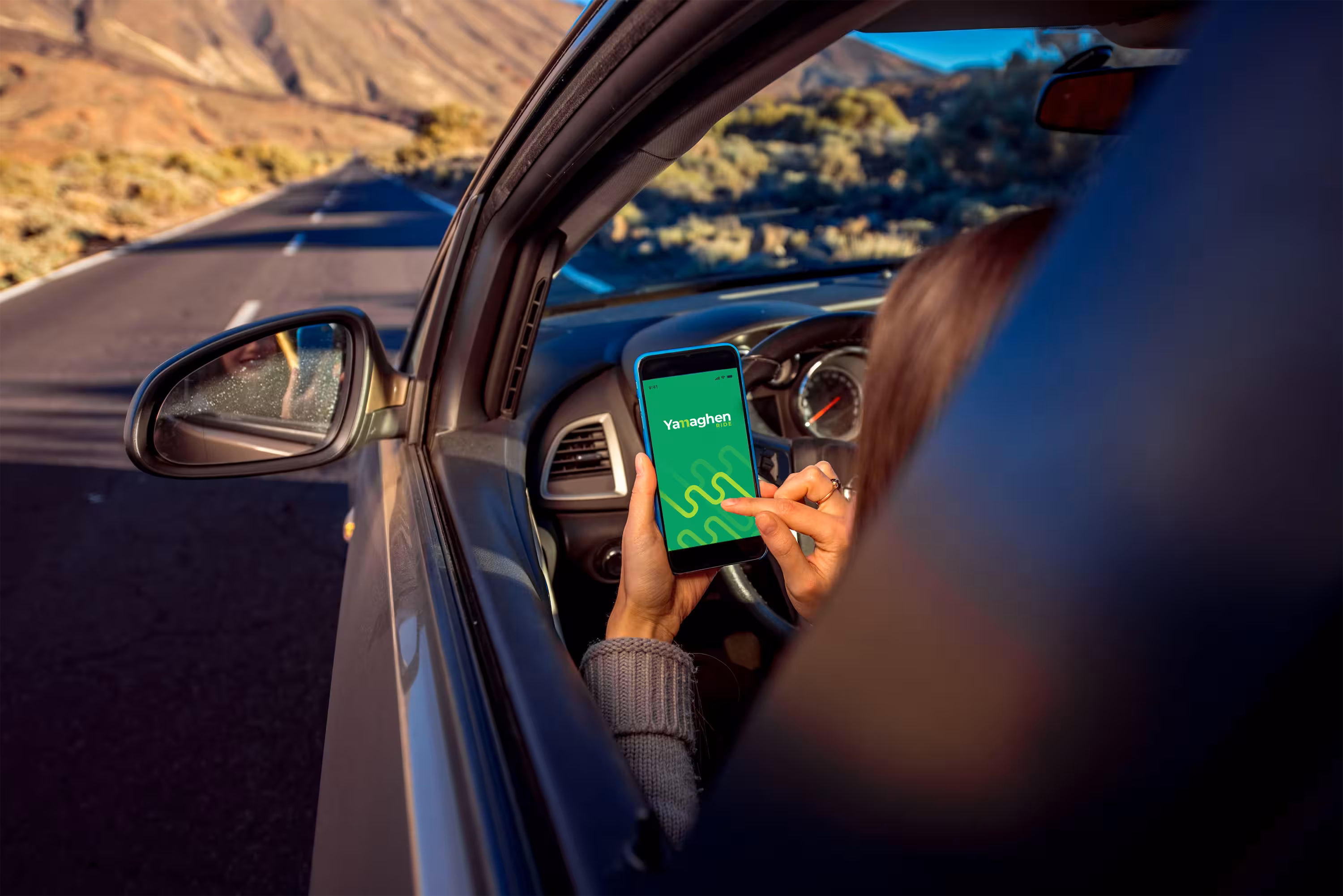 Fahrer schaut auf die Yamaghen Driver App auf seinem Smartphone